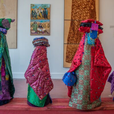 exhibition view of four mixed media sculptures covered in colorful textiles with beadwork by Lahib Jaddo