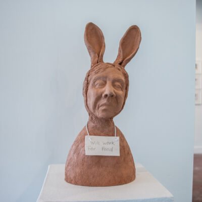 The Rabbit sculpture by Pat Johnson wearing a sign that reads will work for food.