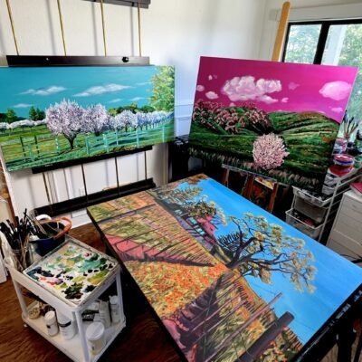 Photograph of Neena Buxani's Studio with three colorful landscape paintings