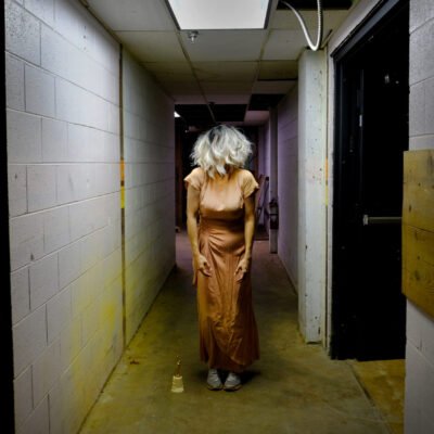 photograph of a woman in a dress in a concrete hallway with hair covering her face by Alyssa Taylor Wendt
