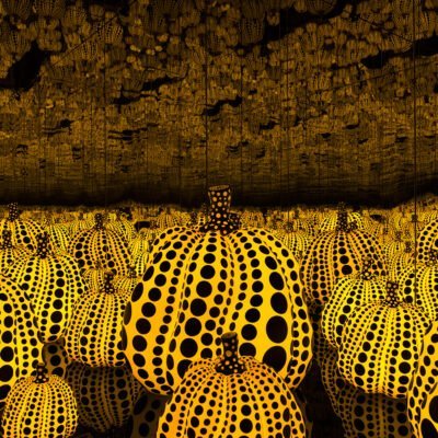 Yellow glowing pumpkins with black polka dots in a mirror covered room titled all the eternal love i have for the pumpkins by Yayoi Kusama