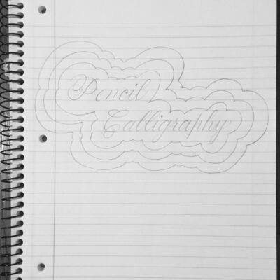 pencil calligraphy written with a border drawn around it in a lined notebook for Andrea Tosten's Script Lettering Workshop