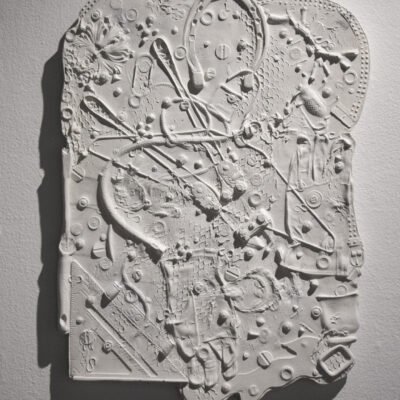 plaster relief sculpture of miscellaneous items, you can see pills, a horseshoe and a protractor.