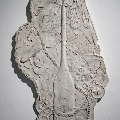 mixed media sculpture of rowing paddle, imprints of beads and other objects are seen on the clay