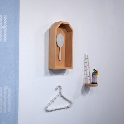 figurines of a hanger, mirror, and figurine of a chinese woman hung on the wall.