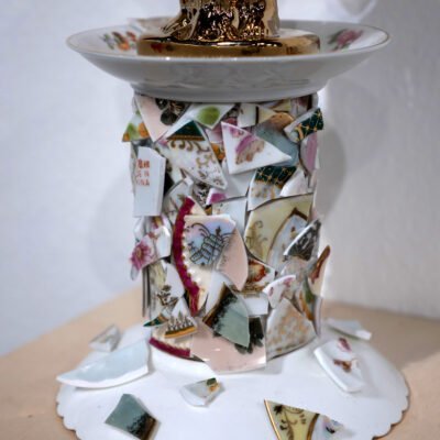 broken teacups and saucers glued onto a glass stand.