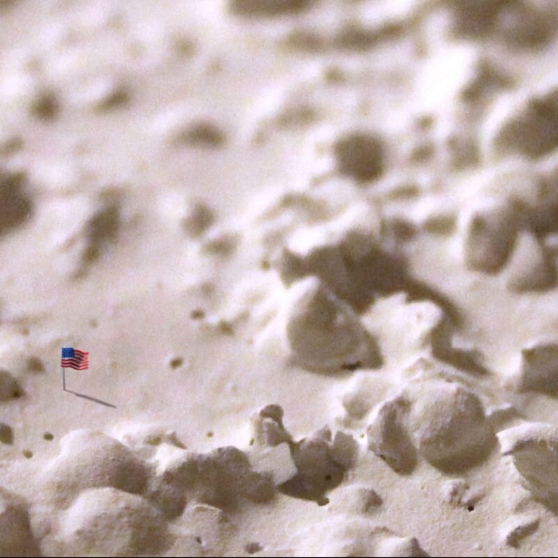 Emily Fleisher, "New Horizons, Bunkbed: Flag"; Digital photograph of clay flag on popcorn ceiling; 10" x 7"