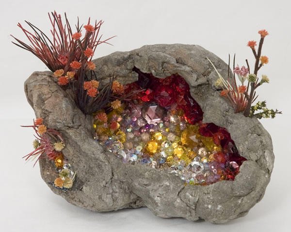 Kia Neill, Geode, 2007. 7'' h. 9'' w. 7'' deep. Foam, paper- mache, plaster, rhinestones, plastic flowers. Kia Neill, Geode, 2007. 7'' h. 9'' w. 7'' deep. Foam, paper- mache, plaster, rhinestones, plastic flowers.